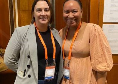 Two women standing next to each other at a conference discussing ERP software.