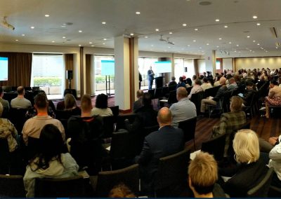 A room full of people watching a presentation on construction management using ERP software in Australia.