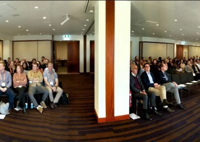 A group of people sitting in a conference room discussing construction management software.