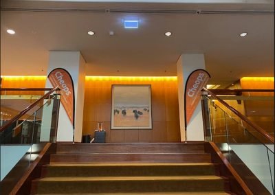A lobby with a painting on the wall, featuring a staircase.