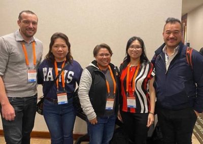 A group of people posing for a photo in a conference room, discussing ERP software.
