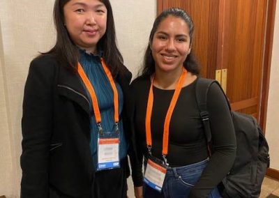 Two women wearing lanyards standing next to each other.
