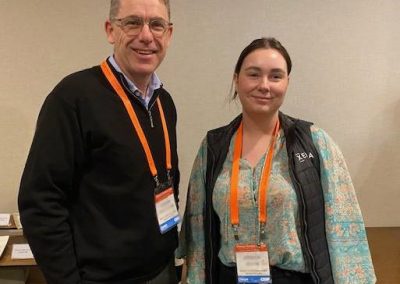 A man and woman standing next to each other at a conference discussing construction management software.